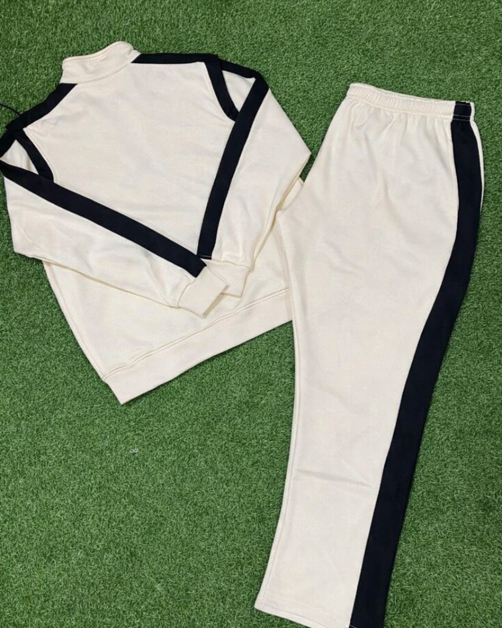 White martial arts uniform with black trim on a green grass background