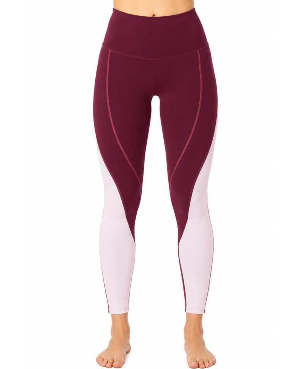 A person wearing high-waisted colorblock leggings in deep burgundy and pale pink, shown from the waist down against a plain white background.