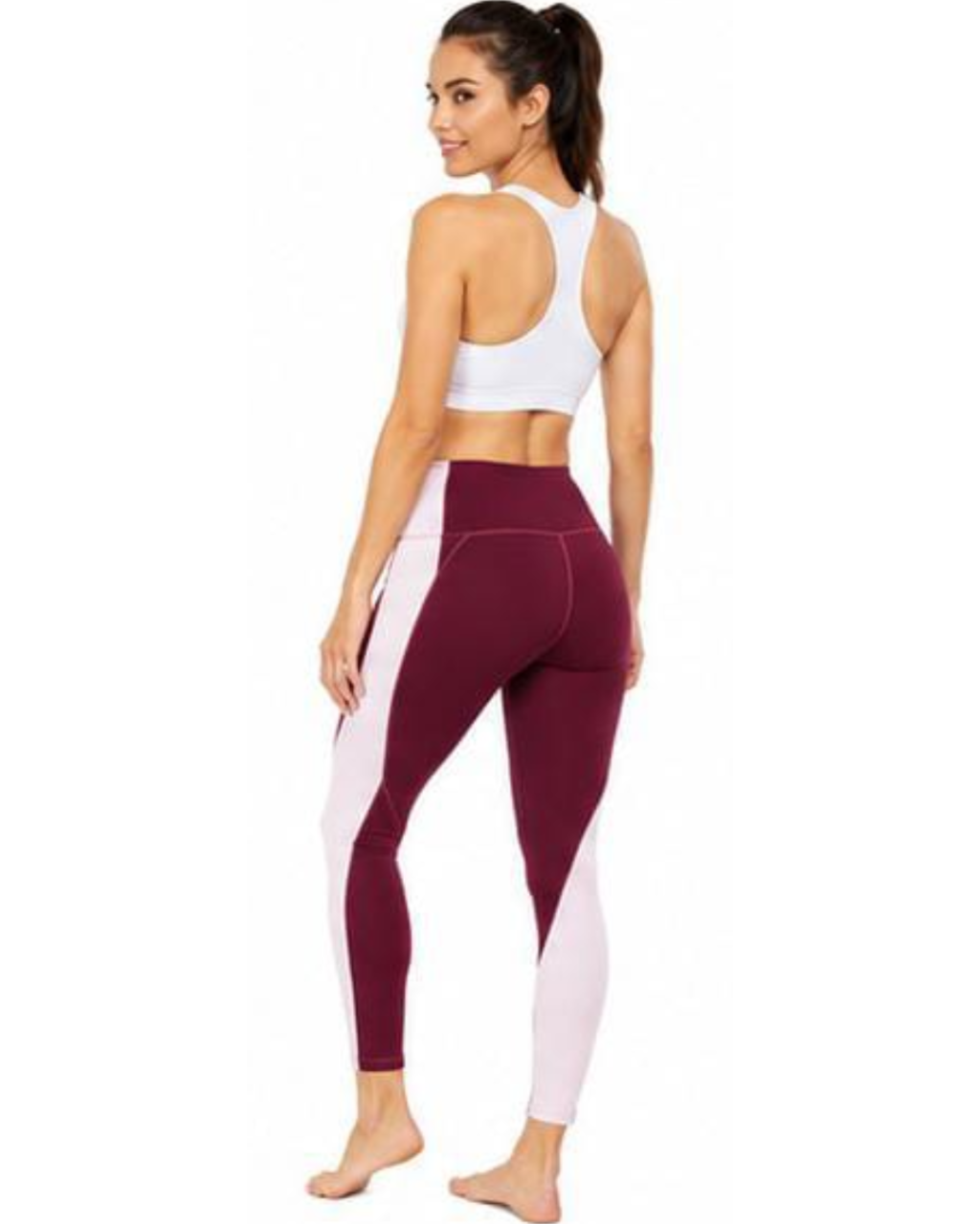 A woman shown from the back wearing high-waisted colorblock leggings in burgundy and light pink, paired with a white sports bra, against a plain white background.