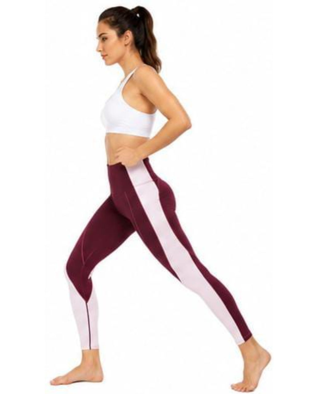 A woman in side profile wearing colorblock athletic leggings in burgundy and white, paired with a white sports bra, against a plain white background.