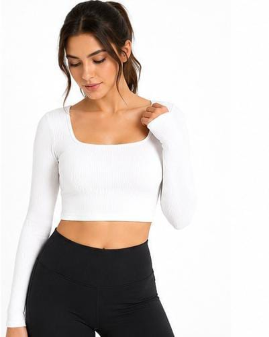 A woman wearing a white long-sleeve ribbed crop top with a square neckline and black leggings, photographed against a plain white background.
