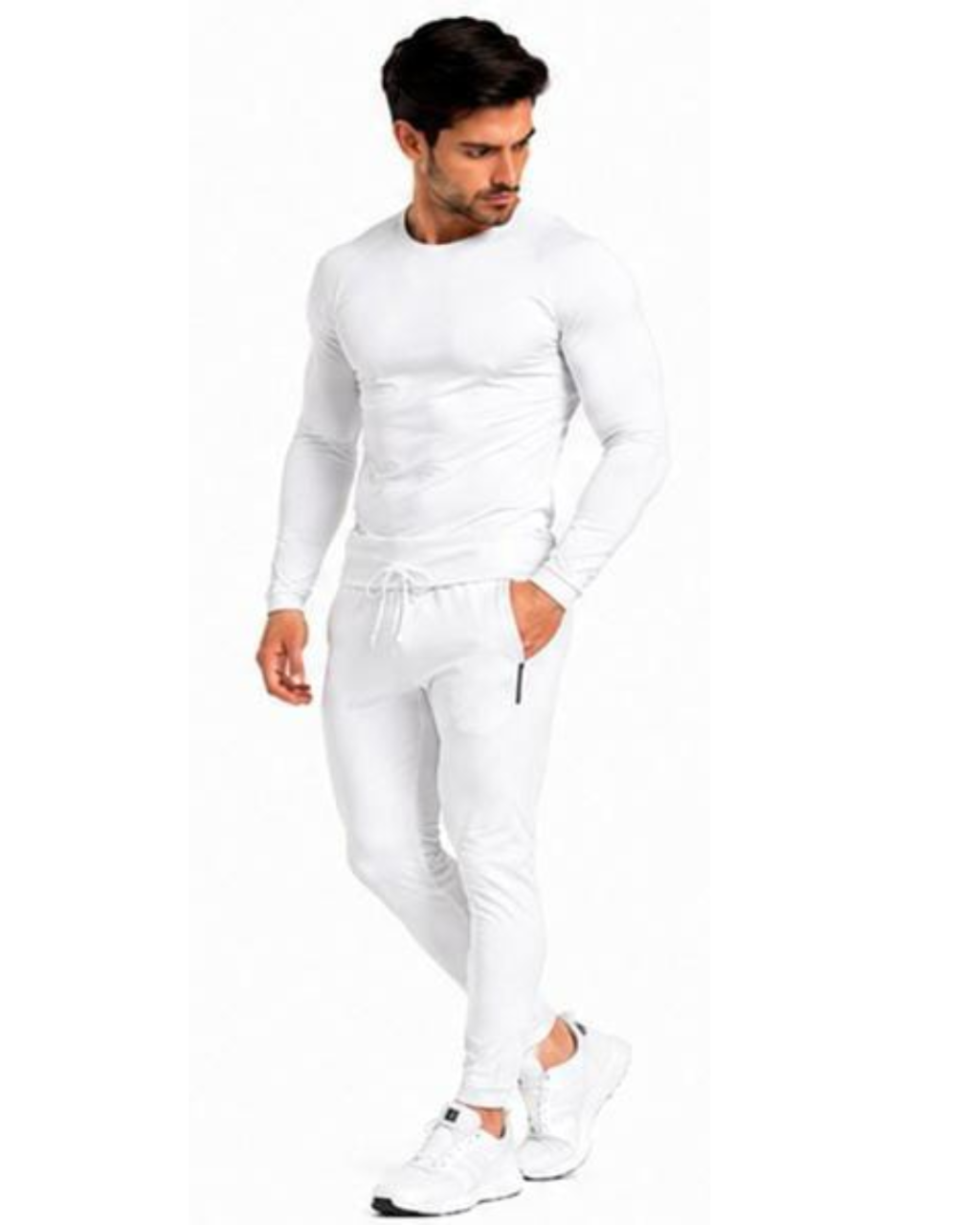 A man modeling a tight-fitting white long-sleeve athletic top and matching white jogger pants with white sneakers, set against a plain white background.