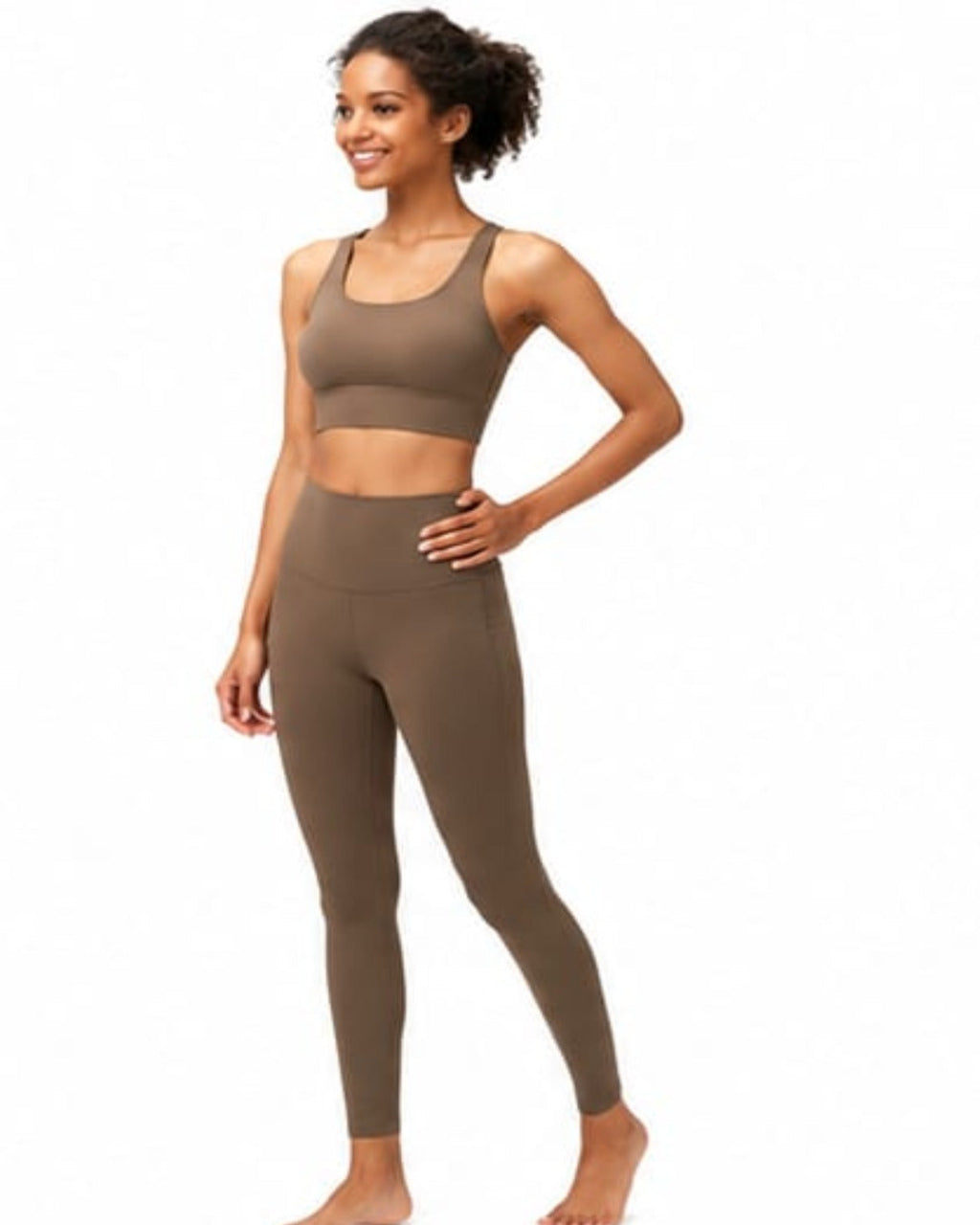 Woman wearing a brown sports bra and leggings set on a white background