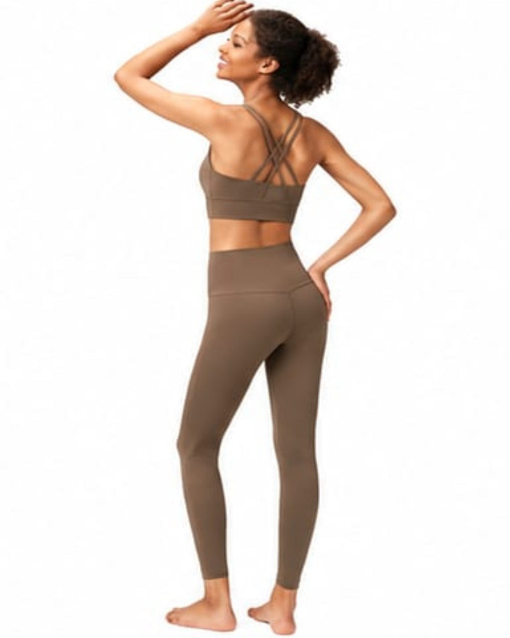 Woman wearing a brown sports bra and leggings on a white background