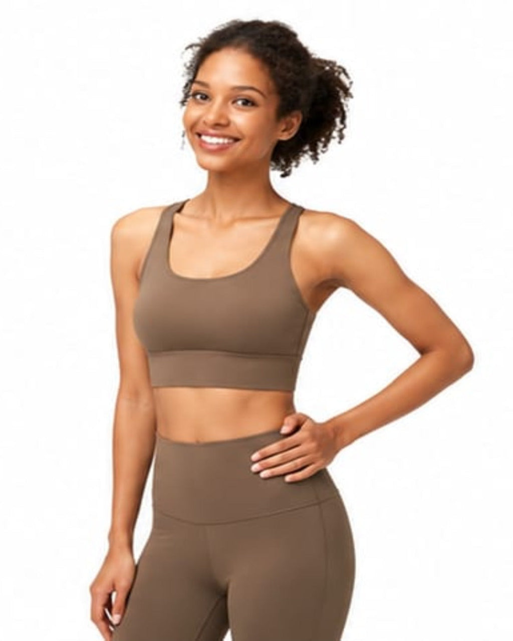 Woman wearing a brown sports bra and leggings on a white background