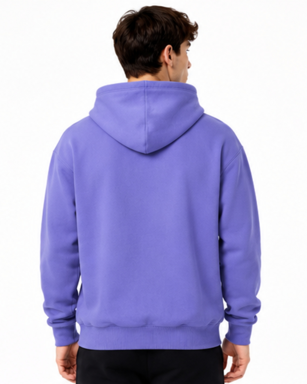 A man viewed from behind wearing a solid purple pullover hoodie with black pants, set against a plain white studio background.