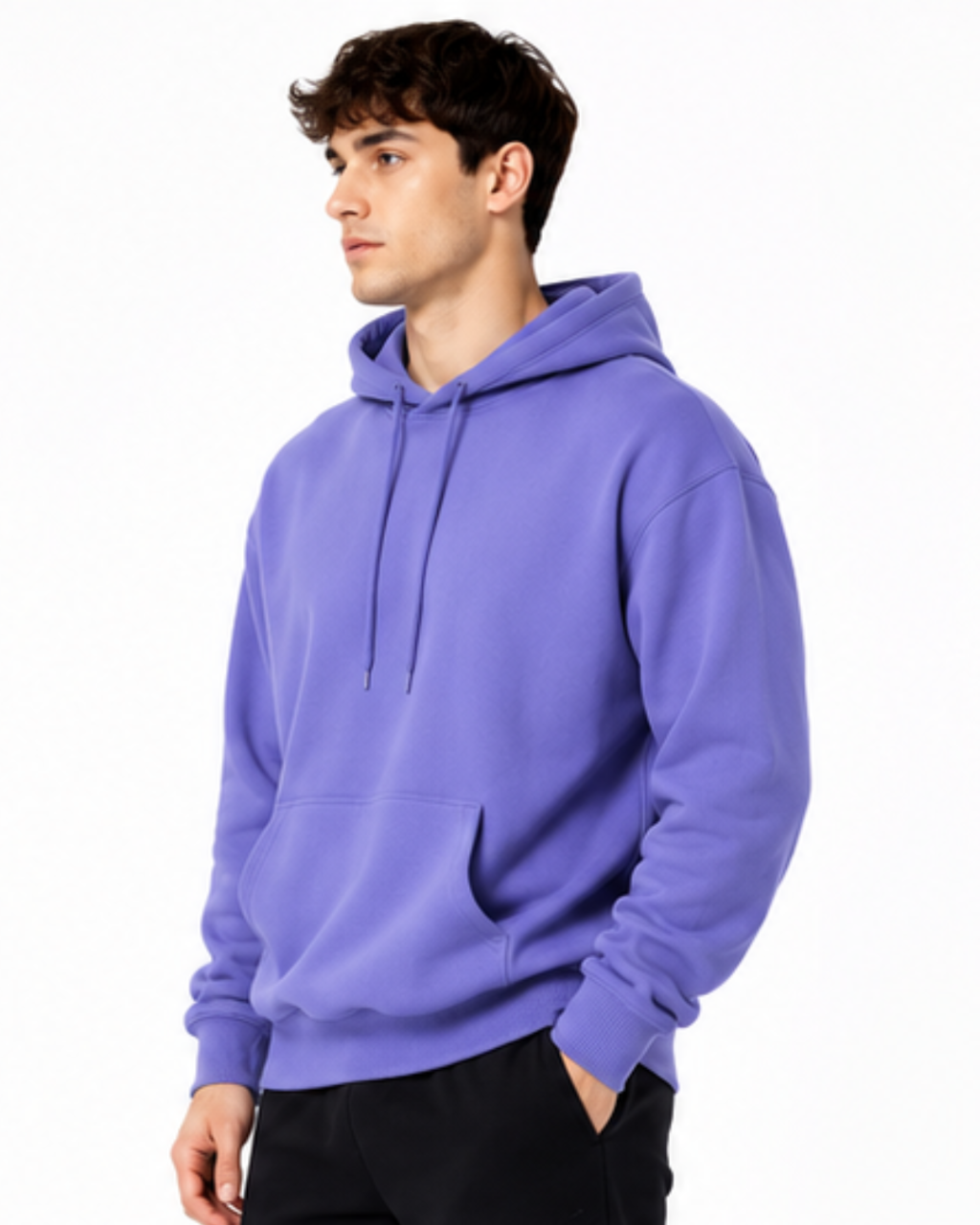A man wearing a solid purple pullover hoodie with drawstrings and a front kangaroo pocket, paired with black pants, photographed against a clean white background.