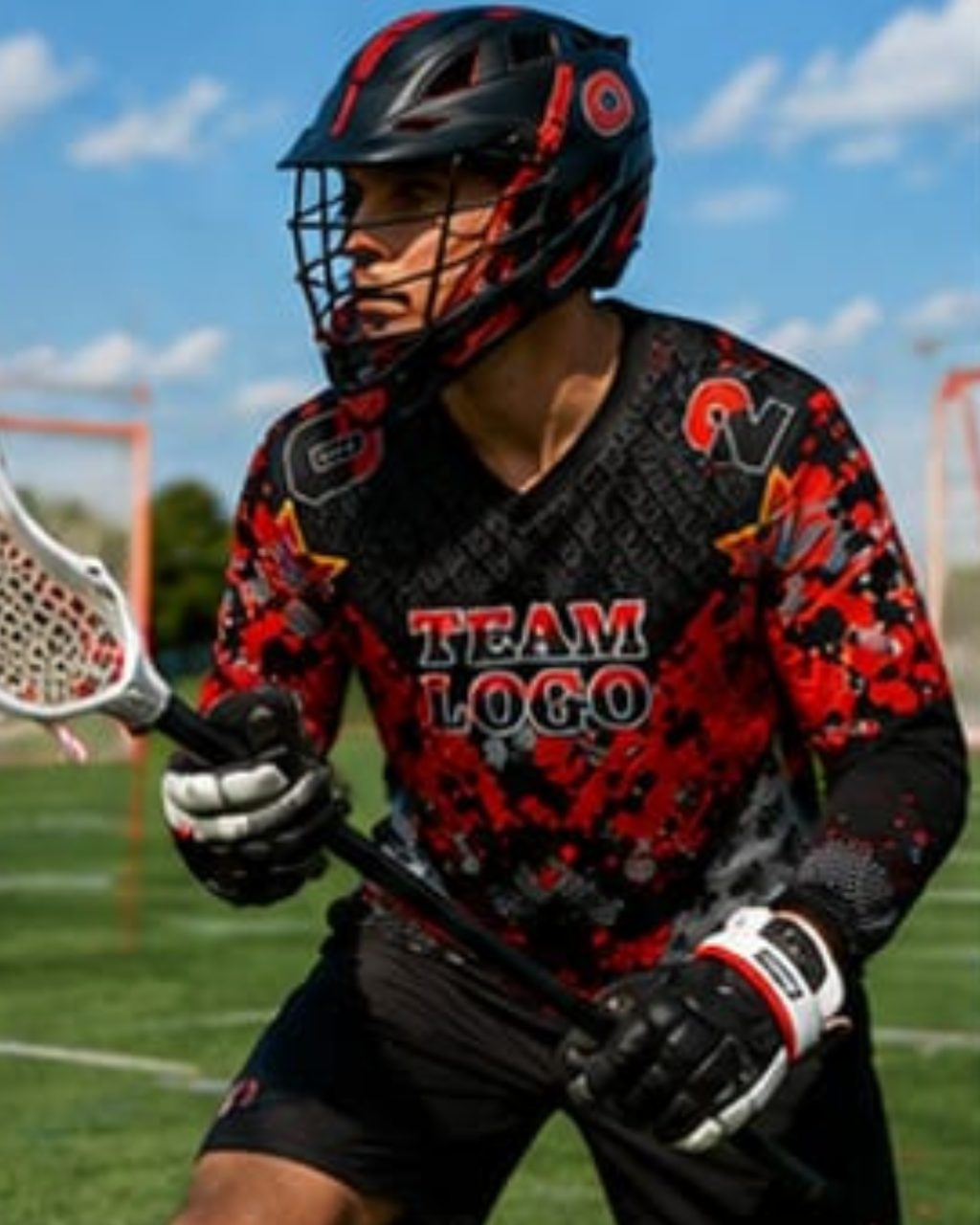 A lacrosse player wearing a black and red patterned lacrosse jersey, black lacrosse helmet with face guard, and black gloves on an outdoor field under a blue sky.
