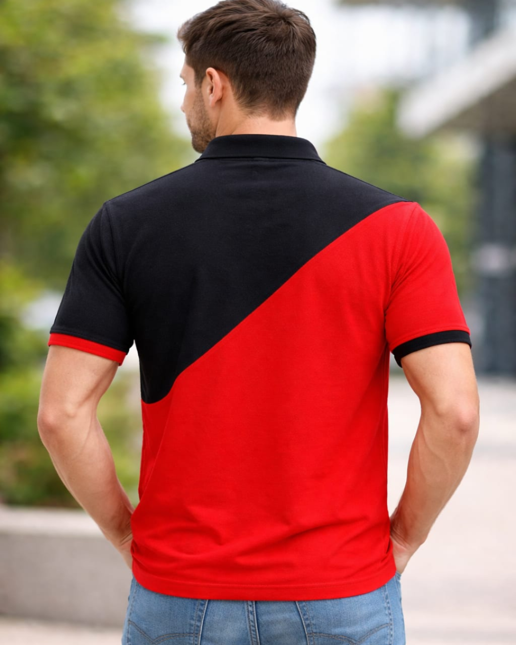 Man wearing a black and red polo shirt with a blurred outdoor background