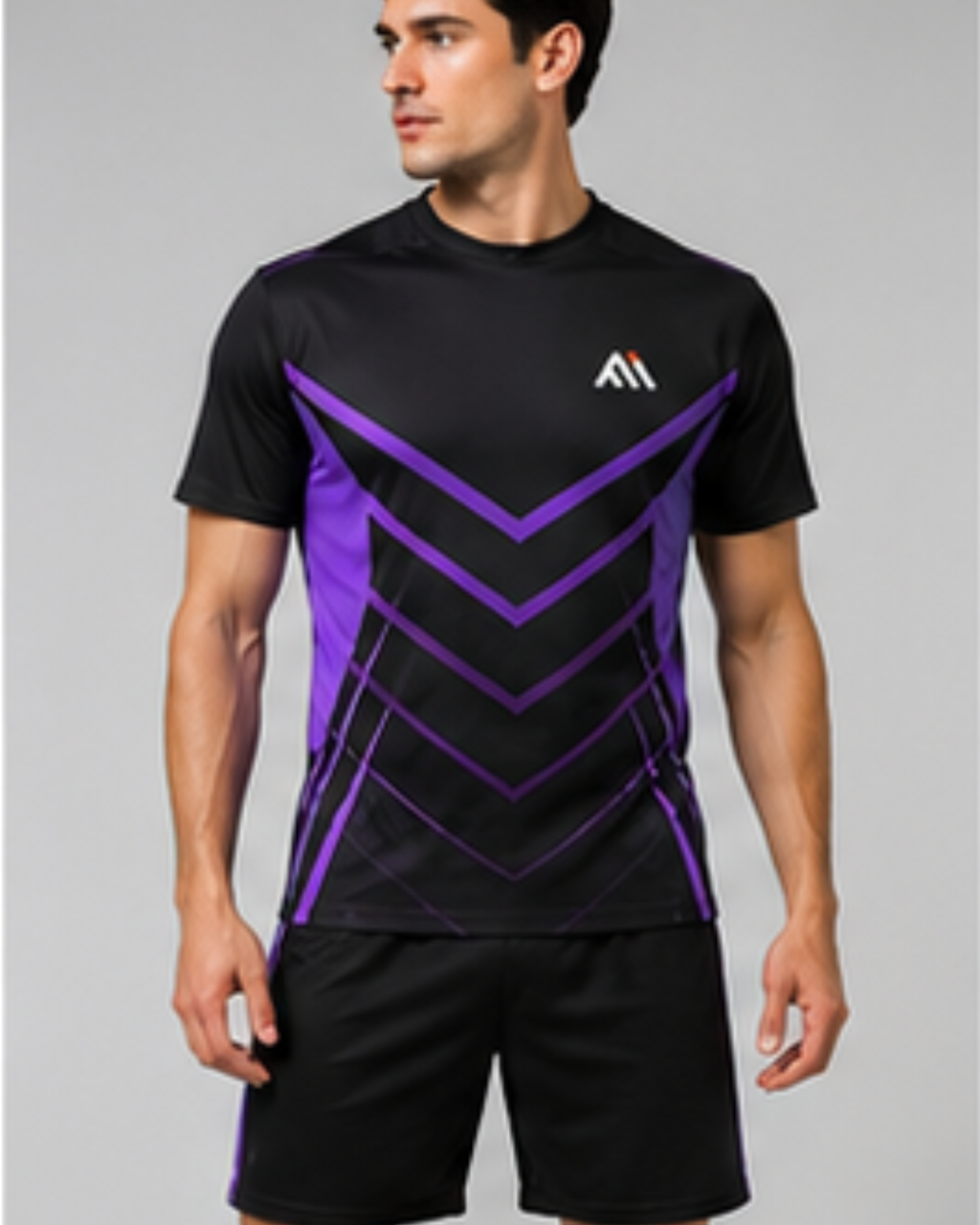 A man wearing a black athletic t-shirt with a purple geometric chevron pattern on the front and a white stylized 'M' logo on the left chest, paired with black athletic shorts, against a solid gray studio background.