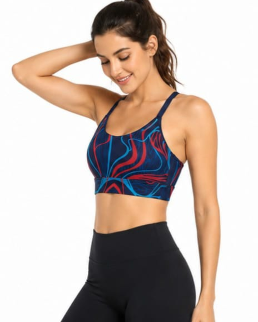 A woman wearing a sports bra with a blue, red, and black abstract swirl pattern, paired with black high-waisted leggings, against a plain white background.